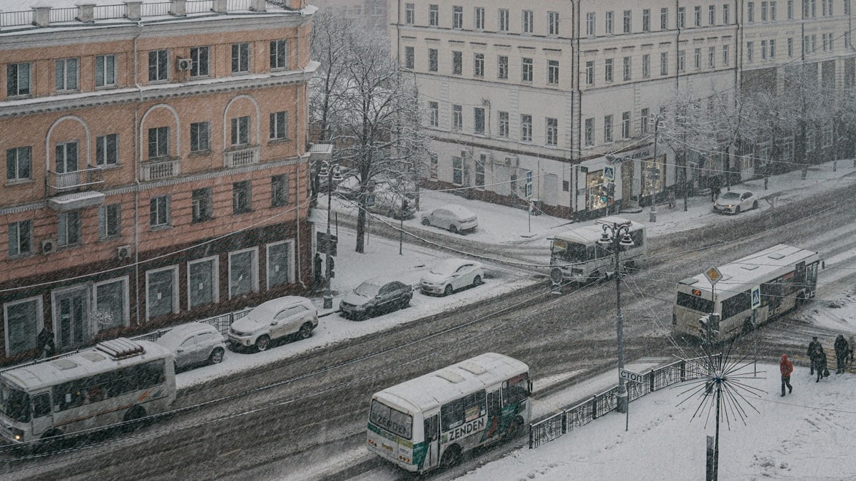 a couple of buses that are sitting in the snow